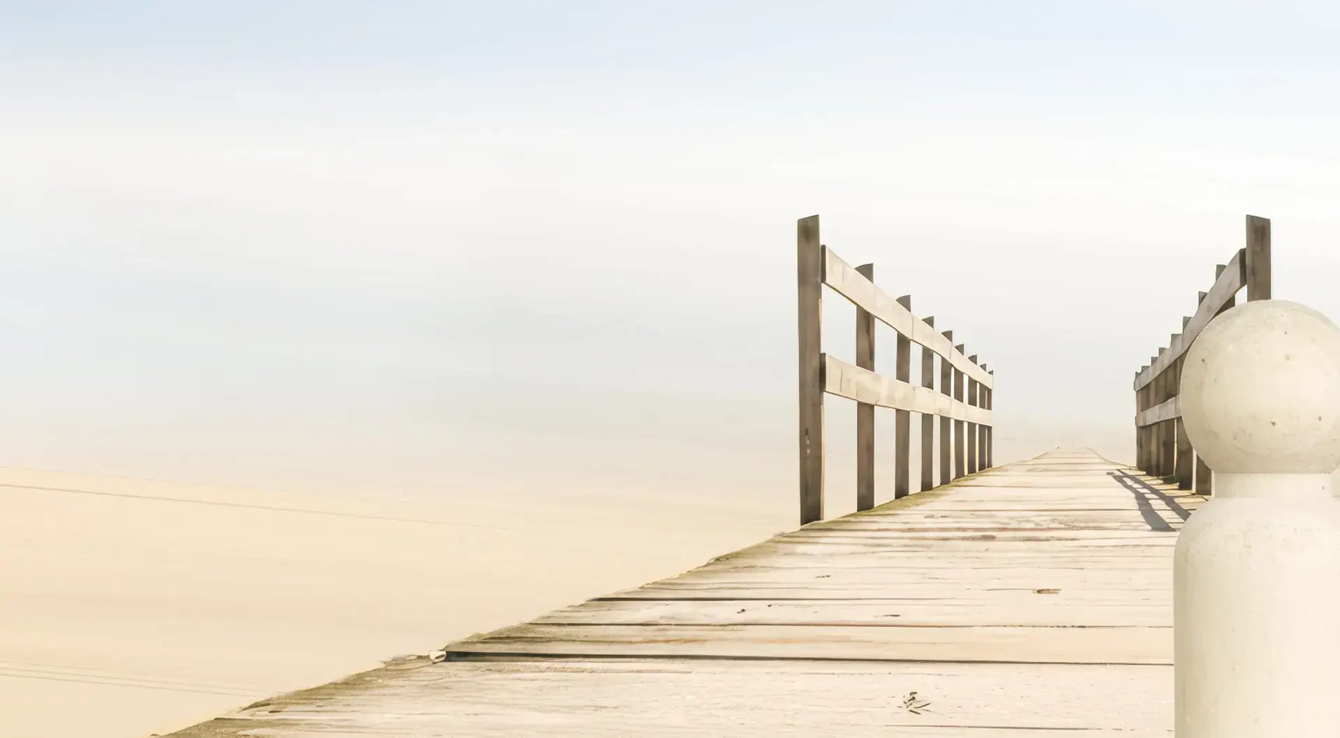 Heller Holzsteg am ruhigen Wasser mit seitlichen Geländern und weichem Morgenlicht, das eine klare, ruhige Atmosphäre für Veränderung schafft.